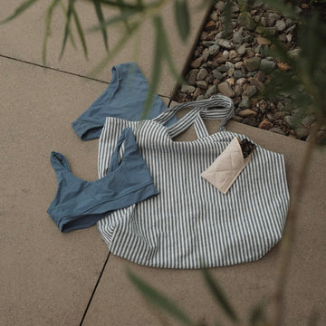 sac rayé marine au sol avec lunettes et maillot de bain